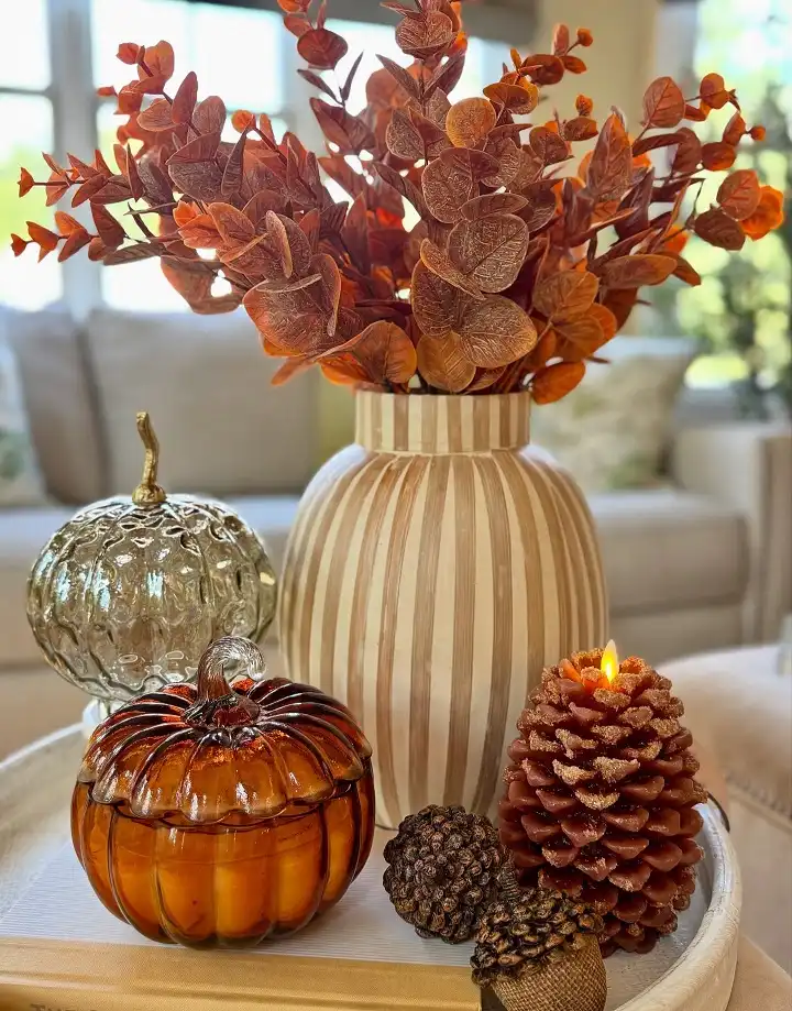 Warm Toned Stems and a Pinecone Candle on One Round Tray