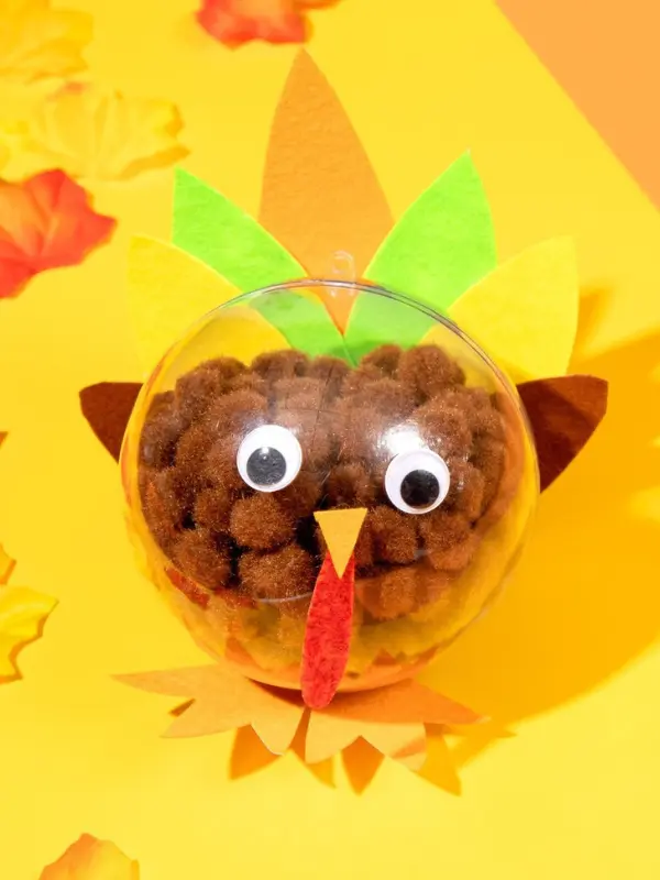 17 Creative Thanksgiving Craft Ideas For Kids To Make This Year 8 Clear Ornament Pom-Pom Turkey