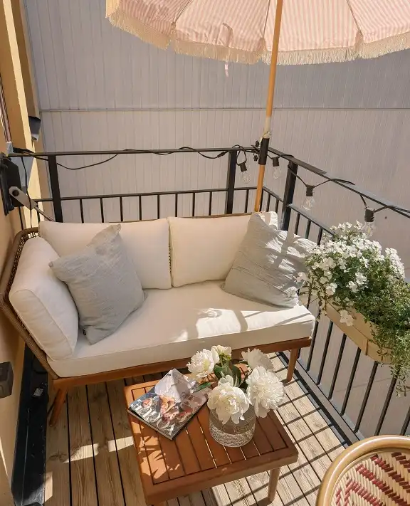 17 Small Balcony Ideas For Apartment Renters 4 Loveseat Lounge Under a Striped Umbrella